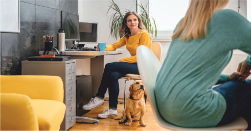 two women in an office with a dog