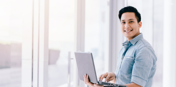 A smiling office worker with a laptop