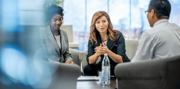 three people having a meeting in an office lounge